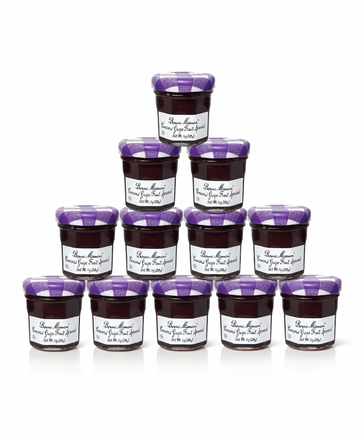 A stacked pyramid of twelve jars of Concord Grape Bonne Maman fruit spread with purple lids and labels on a white background