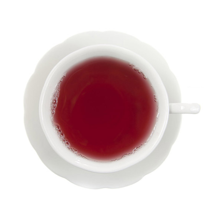 A white ceramic teacup with a matching saucer, filled with a deep red beverage, photographed from directly above on a white background.