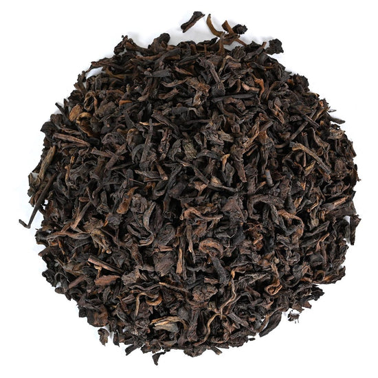 Dark dried black tea leaves on a white background