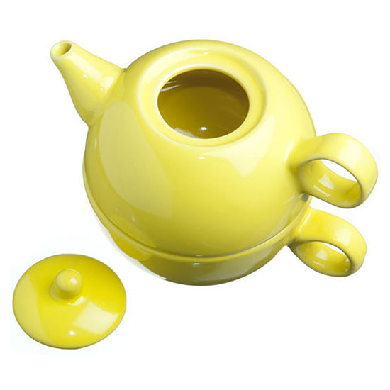 Yellow ceramic tea for one tea set with the teapot stacked on the matching lid on a white background with the lid on the side.