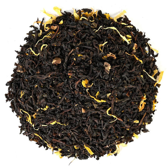 Loose-leaf black tea leaves with yellow strands on a white background