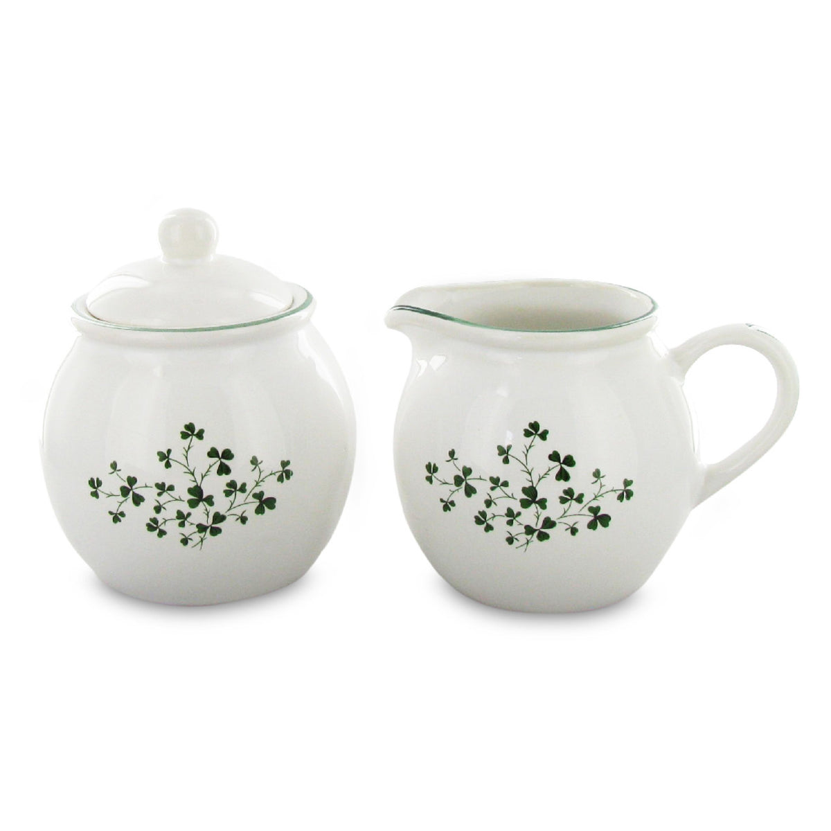 White ceramic sugar bowl and creamer set with green floral patterns on a white background