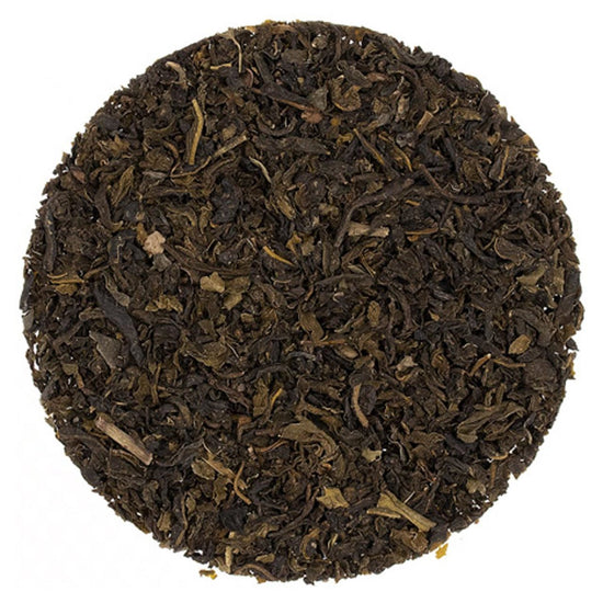 Close-up of dark brown tea leaves on a white background