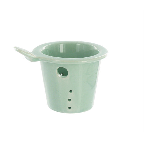 Mint green teapot ceramic infuser on a white background