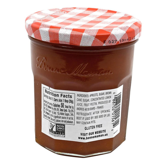Back of a ar of Bonne Maman apricot preserves with a checkered lid on a white background featuring nutrition and ingredients.