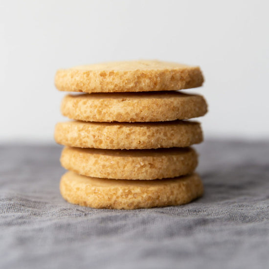 Stack of five Walker's Highlanders shortbread cookies on a grey tablecloth and a white backdrop