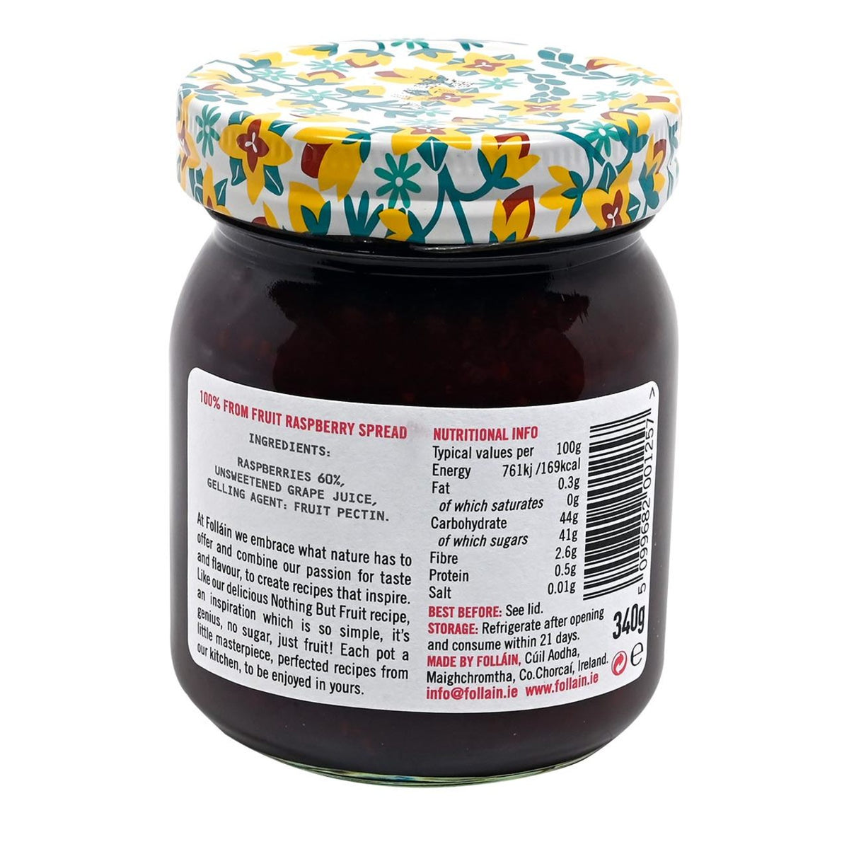 Back of a jar of Folláin raspberry jam with a floral lid on a white background with label displaying ingredients and nutrition