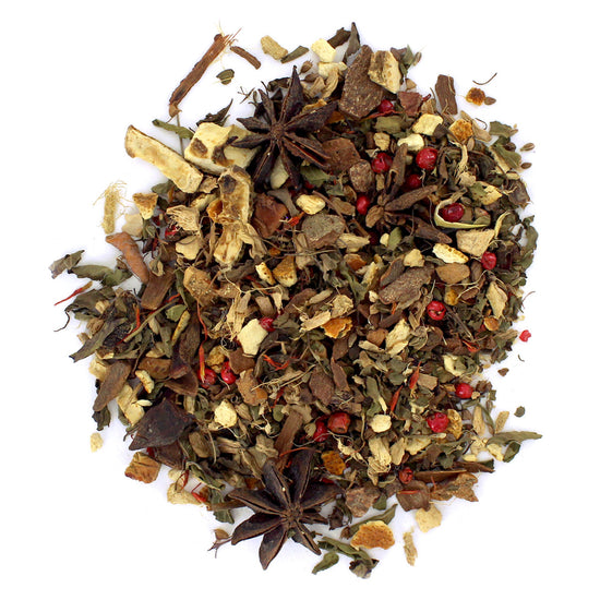A mixture of dried loose-leaf tea and spices used for tea, including leaves, peppercorns, and slices of orange.