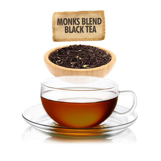 Amber colored tea in clear teacup on a saucer with an all white background. A wooden bowl of dried black tea leaves and label for Monks Blend Black Tea is at the top.