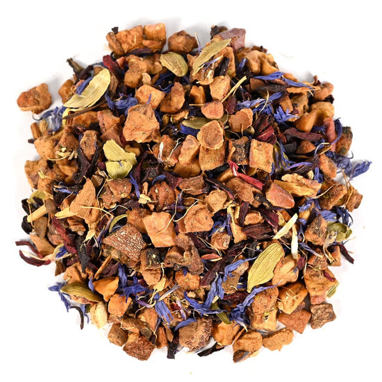 Heap of dried tea leaves, fruit pieces, and nut pieces with blue flower petals on a white background