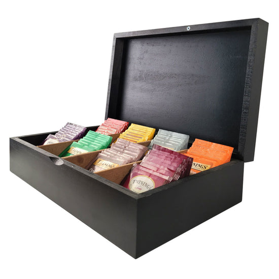 Black wooden box with compartments containing various colored packets on a white background
