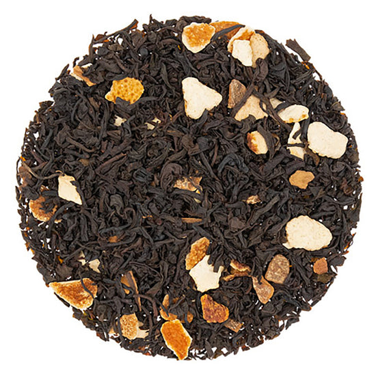 Black tea leaves and visible spices in a circular pattern on a white background