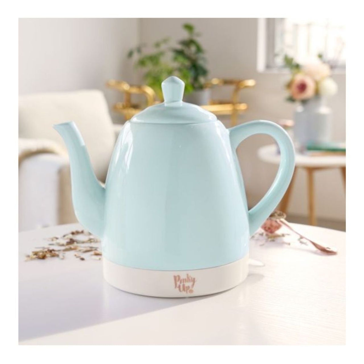 Light blue electric kettle on a kitchen counter with a blurred background