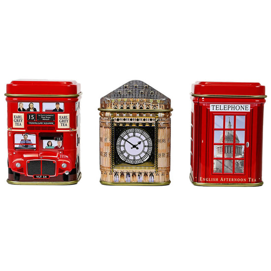 Three tea tins with London-themed designs featuring red double decker bus, Big Ben, and a red telephone booth all on a white background