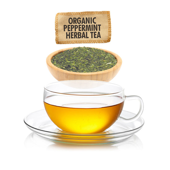 Glass cup of tea with a bowl of organic peppermint herbal tea leaves and packaging on a white background
