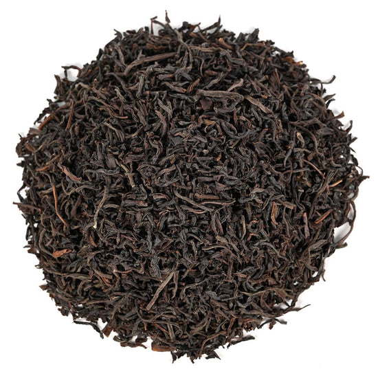 Close-up of dark brown tea leaves on a white background