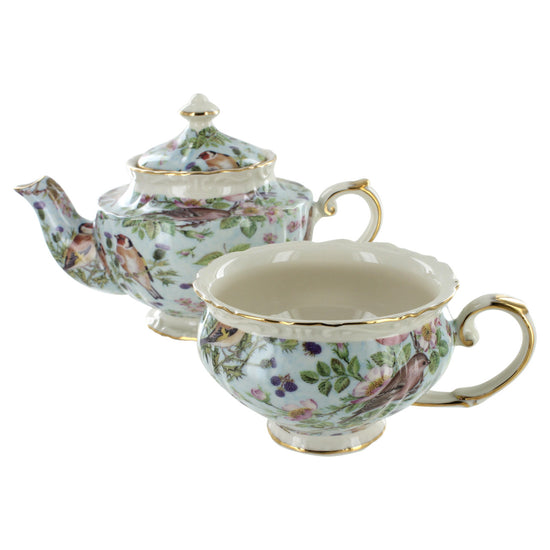 Porcelain teapot and teacup set with floral and bird design on a white background