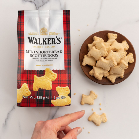 Walker's Mini Shortbread Scottie Dogs packaging with cookies on a plate and marble background