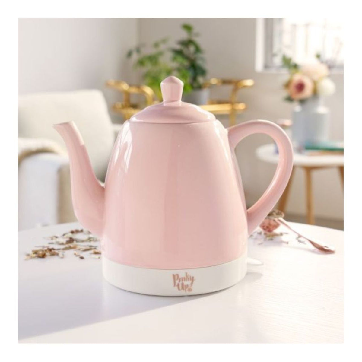 Pink electric kettle on a table with a blurred background