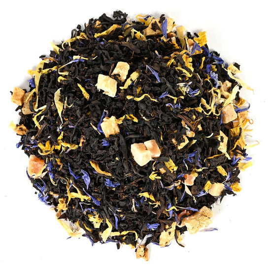 Tea blend with loose-leaf black tea leaves, yellow flowers, and blue petals on a white background