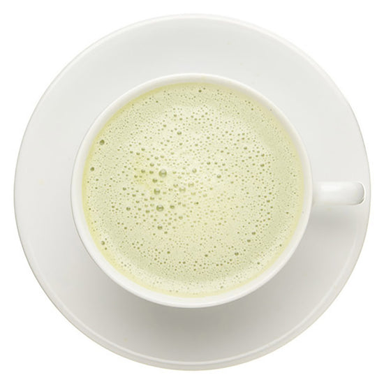 White cup with green tea vanilla matcha white foam layer on a white background