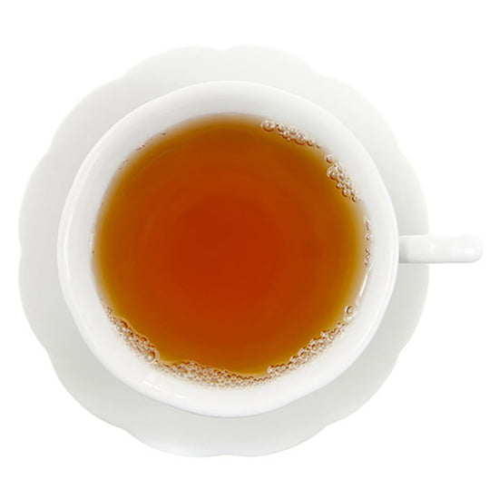 White cup filled with a hot tea on a white background