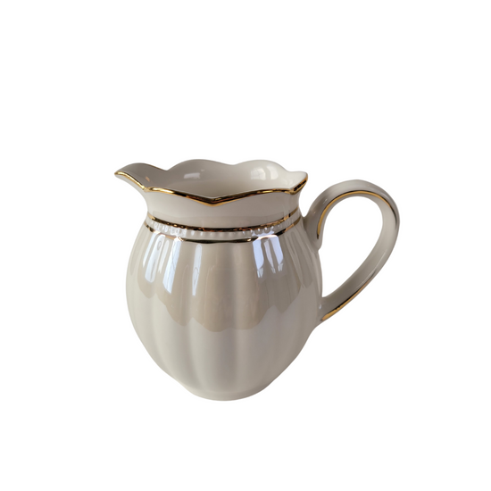 Side view of a Luster Gold Porcelain gold trimmed creamer on a white background