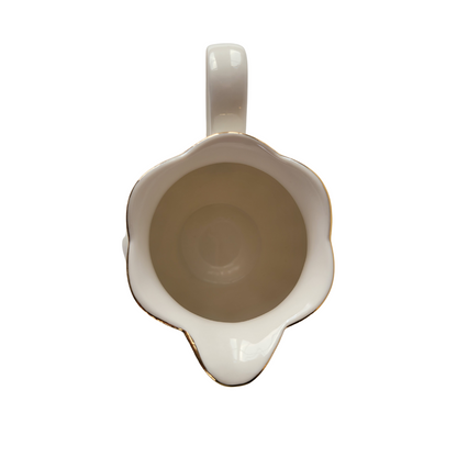 Top-down view of the inside of a Luster Gold Porcelain gold trimmed creamer on a white background