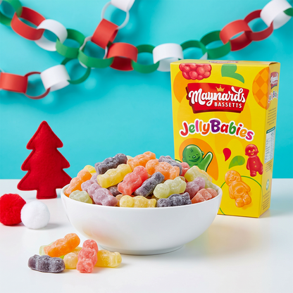 Box of Maynards Jelly Babies with a bowl of colorful candies, paper chains, and a small red Christmas tree.