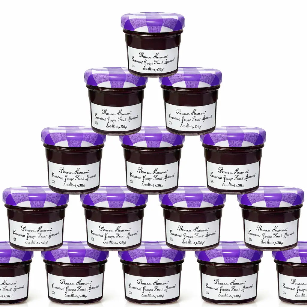 A stacked pyramid of 15 jars of grape flavored Bonne Maman fruit spread.