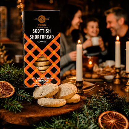 People gathered around a table with a product box, candles, and greenery.