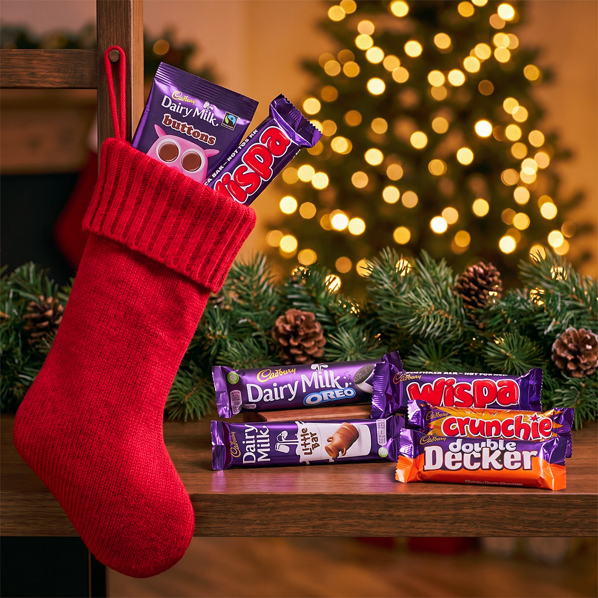 Christmas stocking with chocolate bars and a Christmas tree in the background
