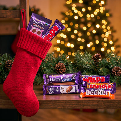 Christmas stocking with chocolate bars and a Christmas tree in the background
