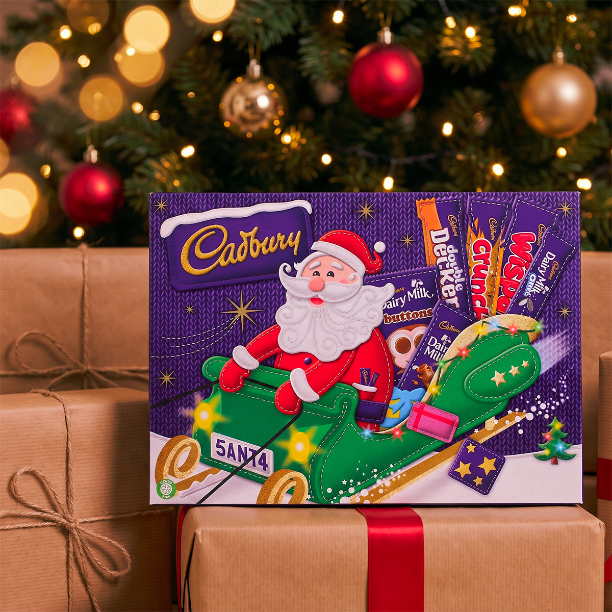 Cadbury advent calendar with a Santa design on wrapped gifts in front of a Christmas tree