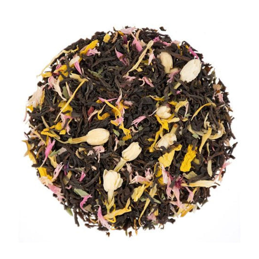 Dry ball of loose-leaf black tea leaves and colorful flowers on a white background
