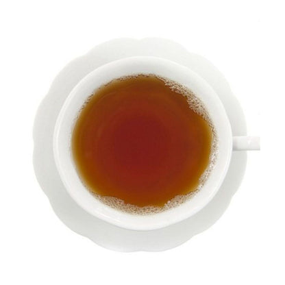 Top-down view of hot tea in a white teacup on a white saucer all on a white background.