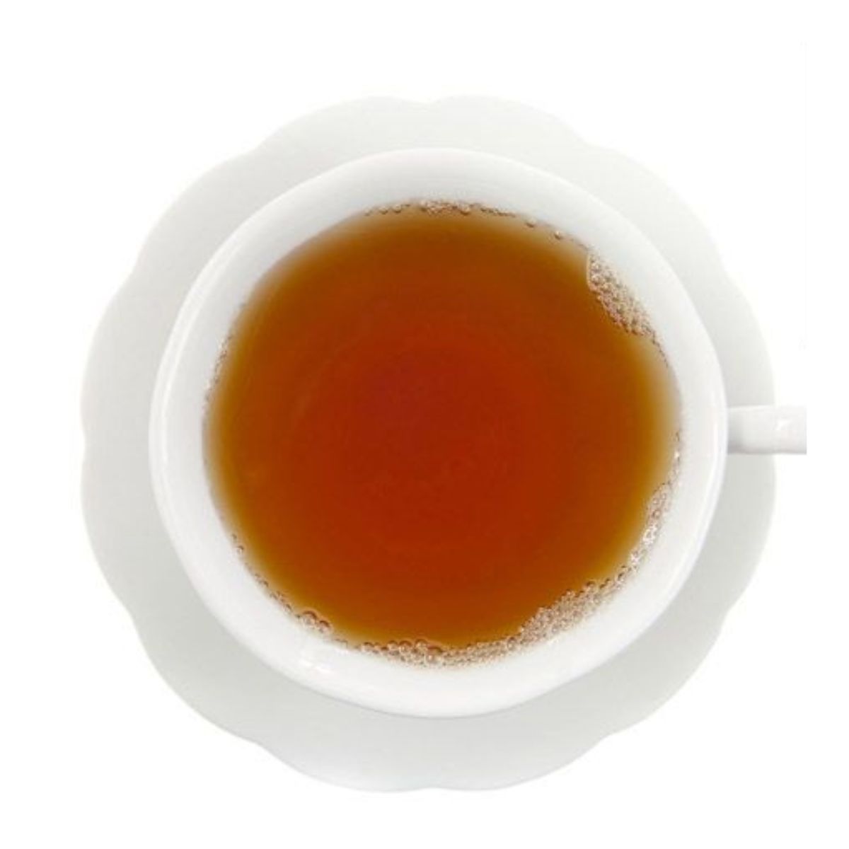 Top-down view of amber hot tea in a white teacup on a white saucer and on a white background.