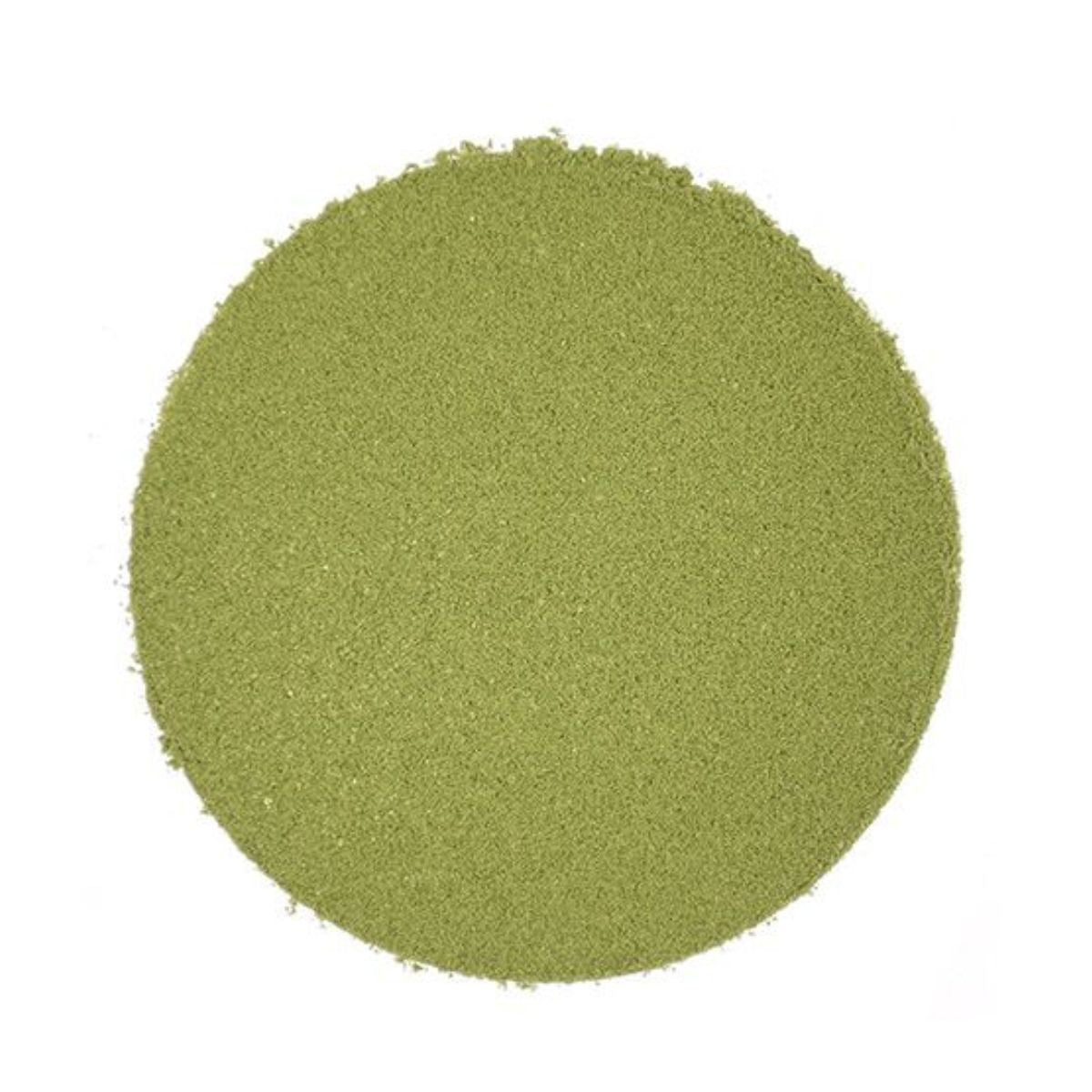 Circular pile of light green matcha powder on a white background.
