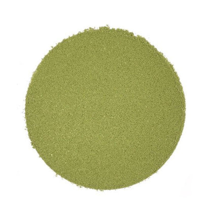 Circular pile of light green matcha powder on a white background.