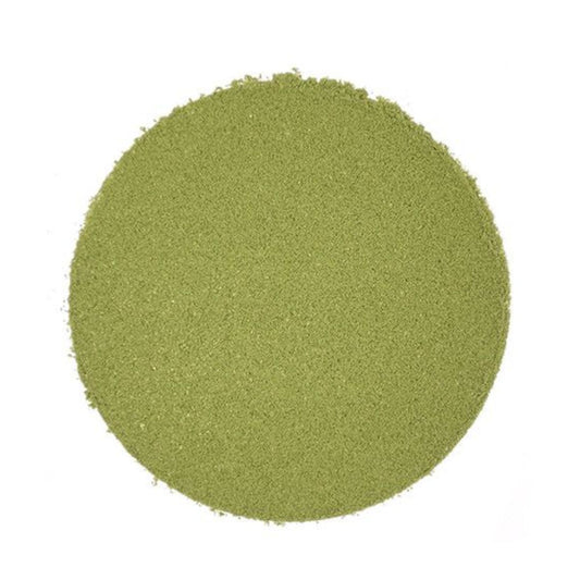 Circular pile of light green matcha powder on a white background.