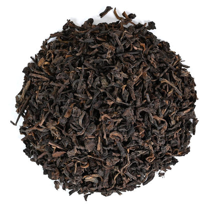 Dark dried black tea leaves on a white background
