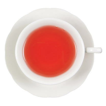 White teacup with light red hot tea on a white background