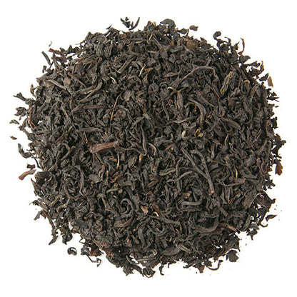 Close-up of Scottish Breakfast dark black tea leaves in a circle on a white background