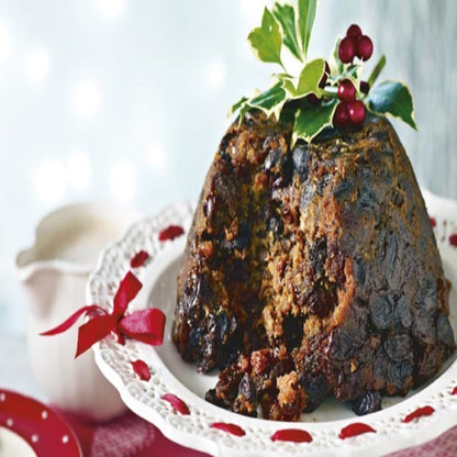 Image of a Christmas Pudding desert on a plate topped with holly. 