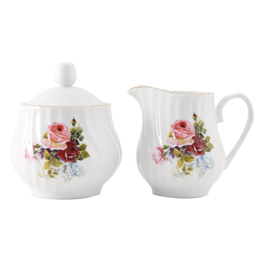 White porcelain sugar bowl and creamer set with floral designs on a white background