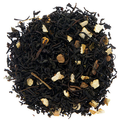 Black tea leaves with some intermixed dried fruit pieces on a white background