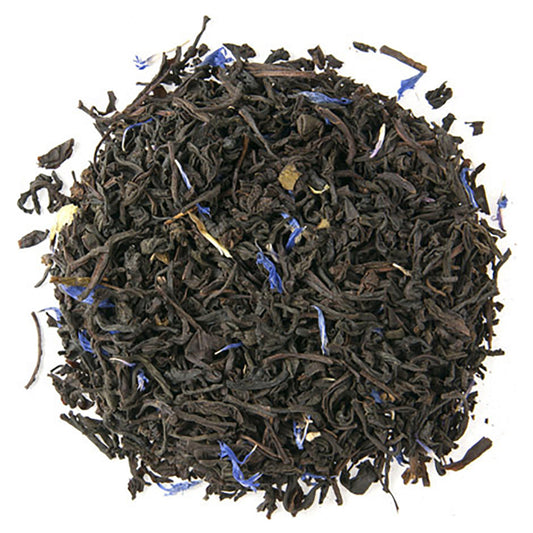Close-up of Early Grey black tea leaves with blue flowers on a white background