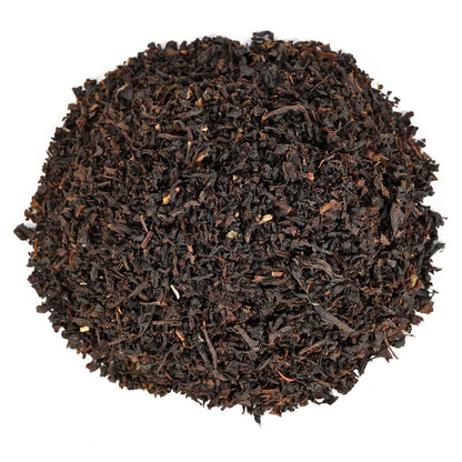 Pile of dark brown tea leaves on a white background