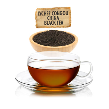 Glass cup of Lychee Congou China Black Tea with tea leaves and packaging on a white background