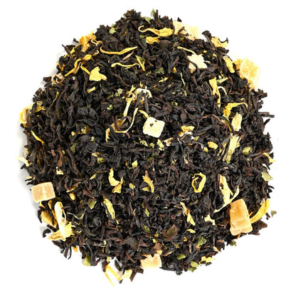 Pile of loose-leaf black tea leaves mixed with yellow flower petals and dried fruit pieces.